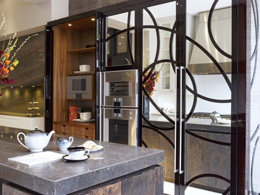 Spectacular Holloways kitchen where sliding doors and panels in dark stained solid walnut and mirrored glass house a Gaggenau oven